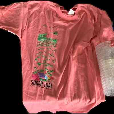 Sugar Loaf, N.Y. T-shirt: A pink T-shirt features a colorful pattern and the text "Sugar Loaf: A Village of Crafts People.