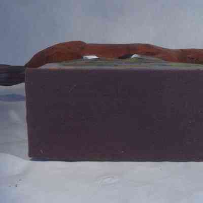 Galloping Horse bottom: A carved wooden horse with a pointed tail rests on top of a rectangular, textured, gray base .
