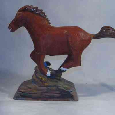 Galloping Horse left side: A wooden horse sculpture is depicted, standing on a textured base, showcasing detailed craftsmanship and dynamic posture.