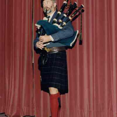 John R. Turner Playing Bagpipes on Ballroom Stage at 50th Anniversary Dinner