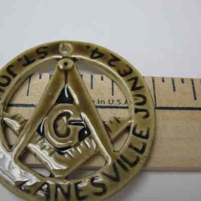 Ornament, Christmas Tree: Ceramic circular ornament inscribed with "St John's Day, Zanesville, June 24th". Beige colored with brown writing.