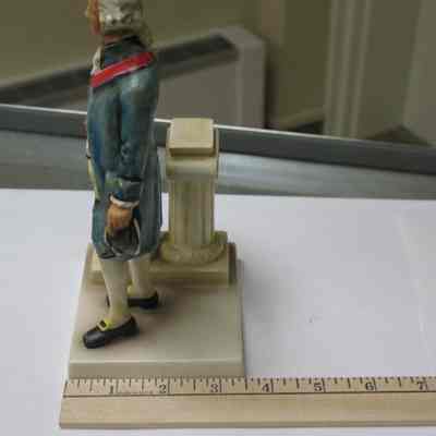 Figurine: Painted ceramic figurine of George Washington wearing a Masonic apron and Master's Jewel holding a gavel. Blue coat and black shoes. Stamped hv W. Goevel, Western Germany