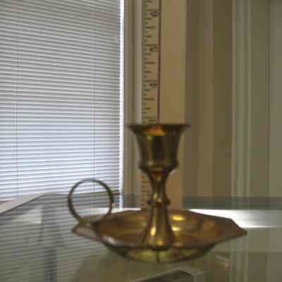 Candleholder: Brass colored single candleholder with handle.