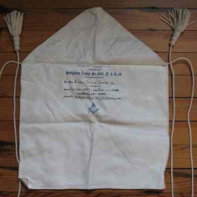 Apron: Printed under flap: "Presented by Sulgrave Lodge No. 696 to Bro. Evan David Jones, Jr.," and the dated of initiation (Nov 26, 1929, Dec 17, 2929, Jan 14, 1930. White leather candidates apron, lined, cotton cord and tassels. 14 1/2" x 12 1/2"