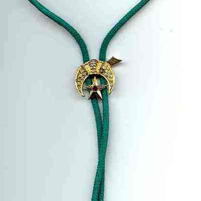 Jewelry: Bolo tie with Shrine emblem. Gold colored with green cord.