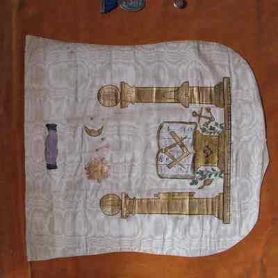 Apron: White silk with cotton backing, hand painted Masonic images in gold paint. No ties or flap. 15 1/2" wide at the top, 14 1/2" wide lower down the apron, 16" high. Believed to be of Civil War vintage.
