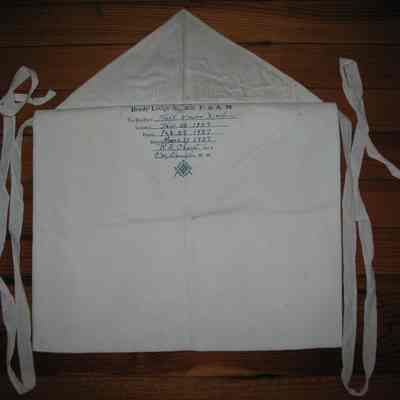 Apron: Printed under flap: "Presented by Brady Lodge No. 208 F&AM to Brother Keith Mason Martin. Initiation: E.A. Jan 28, 1937, F.C. Feb 22, 1937, M.M March 29, 1937". White leather candidates apron, cotton tape ties