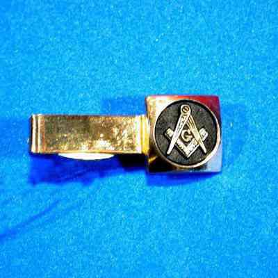 Clip, Tie: Tie clip with Square and Compasses. Gold color with black behind S & C