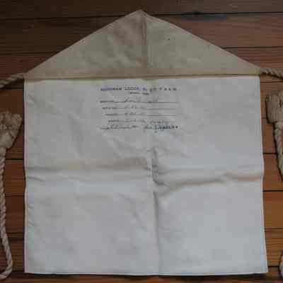 Apron: Printed under flap: "Adoniram Lodge No. 517, F.&A.M., Akronm Ohio:" The dates that Bro Wm. C. Baird was initiated. White leather candidates apron, lined, cotton cord and tassels. 15" x 12"