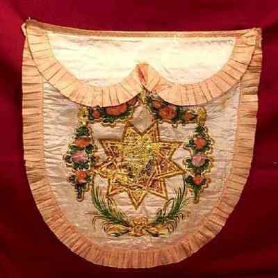 Apron: Wite cloth with pink border. Apron framed. 17" long