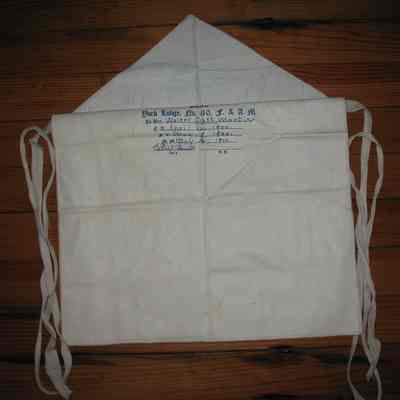 Apron: Printed under flap: "Presented by York Lodge No. 410 to Bro. Walter Scott Martin. Initiation: E.A. April 12, 1900, F.C. May 9, 1900, M.M. May 12, 1900". White leather candidates apron, cotton tape ties.