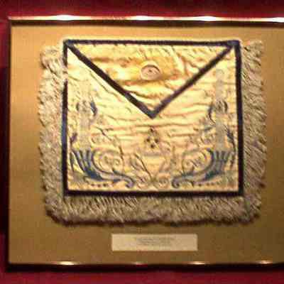 apron: Past Master's apron. White satin, All Seeing Eye on flap, framed. White, blue with light blue stitching