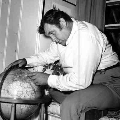 Andy Devine Studing a Globe