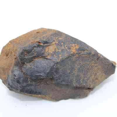 Closeup of basaltic glass core: The image shows a rough basaltic glass core with a dark, glassy surface and some brownish-tan weathering.
