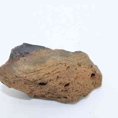 Profile of basaltic glass core: The image shows an irregular piece of basaltic glass core with dark, smooth surfaces and rough, porous texture.