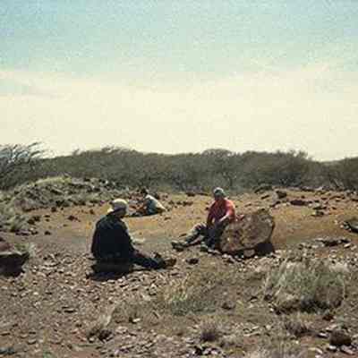 Unidentified people sitting on a potential archaeological site