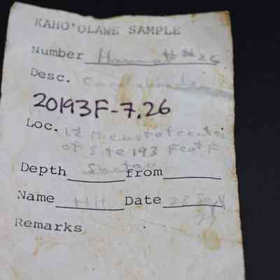 Artifact slip for a coral abrader: The image shows an old, worn artifact slip labeled "Kaho'olawe Sample," for a coral abrader detailing sample number, description, location, and date.