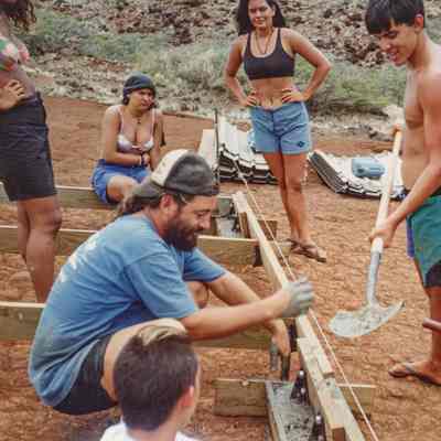 People pouring concrete into wooden forms