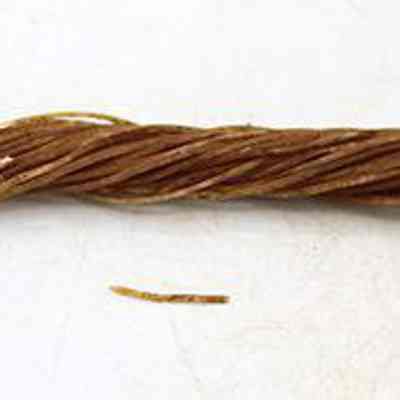 Close up of nylon rope: The image shows a twisted bundle of thin, brown nylon fibers, laying on a flat, light-colored surface.