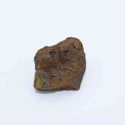 Closeup of basaltic glass core: The image shows a rough, irregular-shaped basaltic glass core with a dark, earthy texture on a plain background.