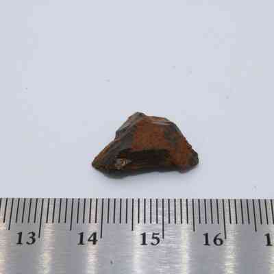 Basaltic glass core with ruler: The image shows a small basaltic glass core fragment placed on a white surface, next to a measuring scale for reference.