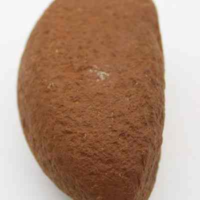 Closeup lengthwise view of breadloaf sinker: The image shows a brown, rough-textured stone sinker, featuring an elongated, oval shape, likely used in fishing activities.