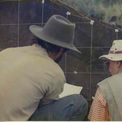 Two people examining petroglyphs (kiʻi pōhaku)