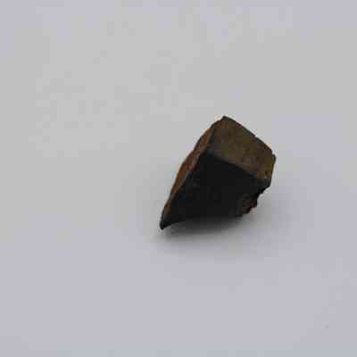 Side of basaltic glass core: The image displays a small, angled piece of dark basaltic glass core against a plain white background.