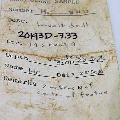 Artifact slip for basalt drill: The image displays a worn, handwritten label for a basalt drill sample, indicating location 193, with depth noted at the surface from 28 Sept.