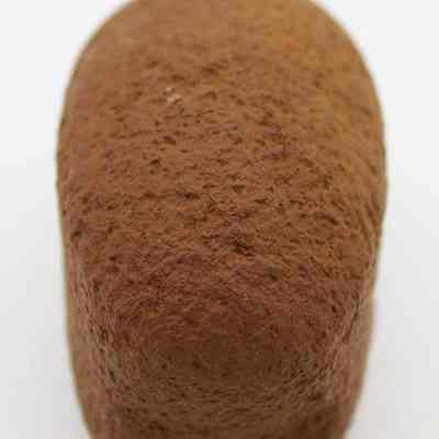 Lengthwise view of breadloaf sinker: The image shows a close-up view of a textured, brown stone, likely a fishing sinker, shaped like a rounded pebble with a rough surface.