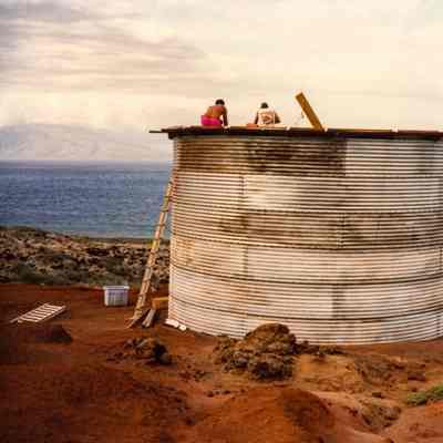 People wokring on top of water catchment structure