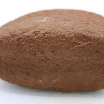 Profile of breadloaf sinker: This image shows a close-up view of a brown, oval-shaped stone sinker, which is designed to weigh down fishing nets or lines effectively.
