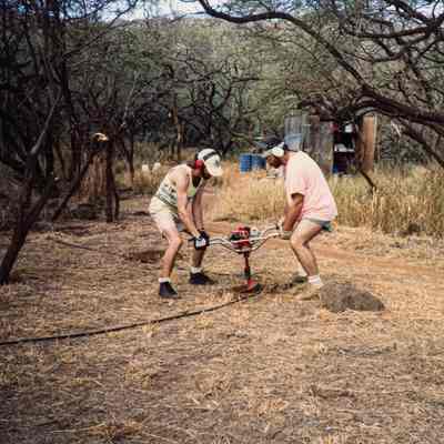 Two men operating an auger