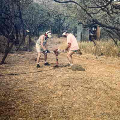 Two men working an auger