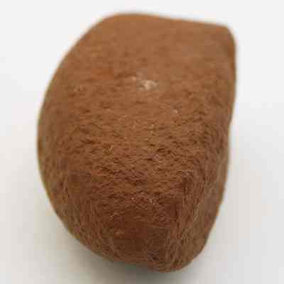 Lengthwise view of breadloaf sinker: The image shows a rough, brown, oval-shaped stone with a textured surface, possibly used as a sinker in fishing.