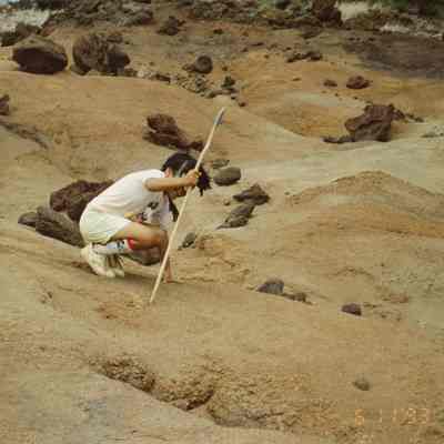 Young person kneeling on hardpan