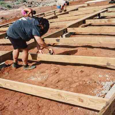 People working on wooden frame of water catchment structure