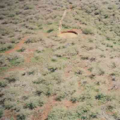Aerial view of circular water structure and hardpan terrain