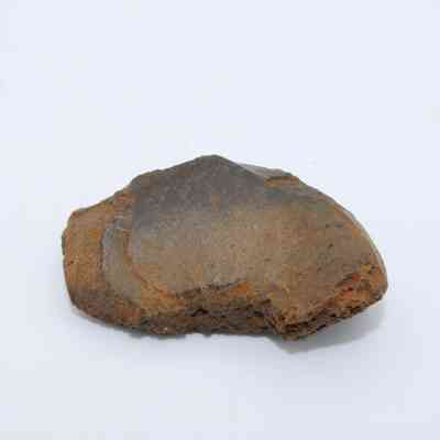 Closeup of glass flake: The image displays a solitary glass flake with rough edges, lying on a plain white surface, showcasing its intricate texture.