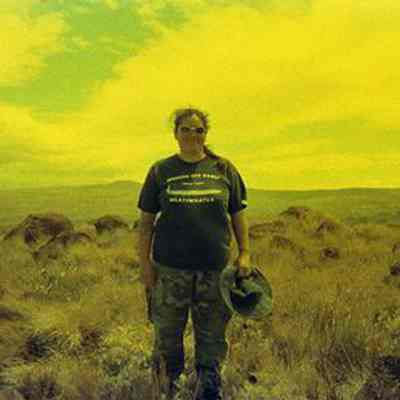 Unidentified woman standing in front of pohaku (stones)