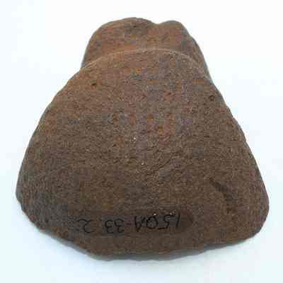 Closeup of grooved type sinker or polishing stone w/alternate id #: The image depicts a rough, brown stone with a flat base, potentially used as a sinker fragment or polishing stone.