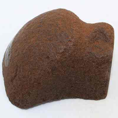 Side profile closeup of grooved type sinker or polishing stone: The image shows a rounded stone object that could be a sinker fragment or a polishing stone, displaying a rough texture.