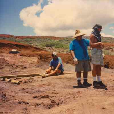 Several men sitting/standing on hardpan