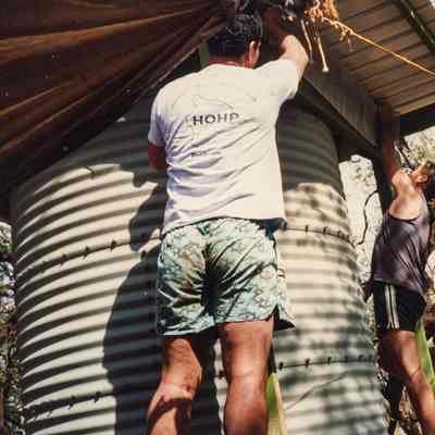 People placing top on water storage structure