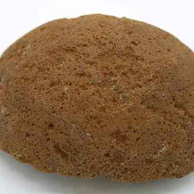 Closeup of the base of a cup or mortar fragment: The image shows a brown, textured, dome-shaped fragment that could be part of an ancient cup or a piece of mortar.