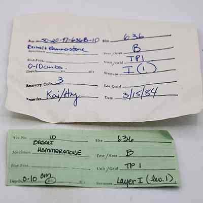 Artifact slips for hammerstone: Two handwritten forms detail specimen information, featuring site, depth, recovery code, and stratum data.