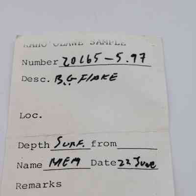 Artifact slip for basaltic glass flake: The image depicts an artifact sample slip with handwritten details, including number, description, depth, and date of entry.