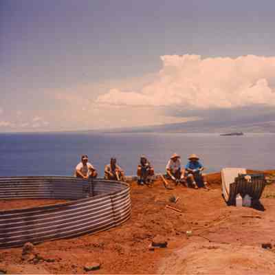 People sitting next to water catchment