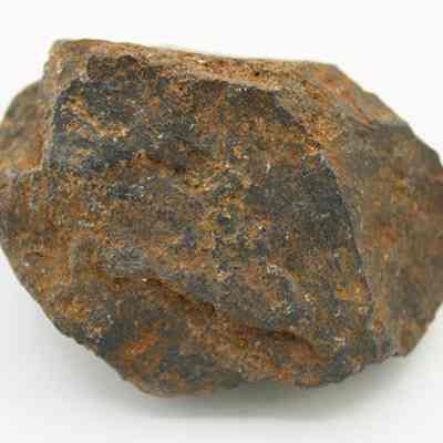 Closeup of hammerstone or core: The image shows a rough, irregularly shaped brown and gray rock with a textured surface,  displayed against a white background.