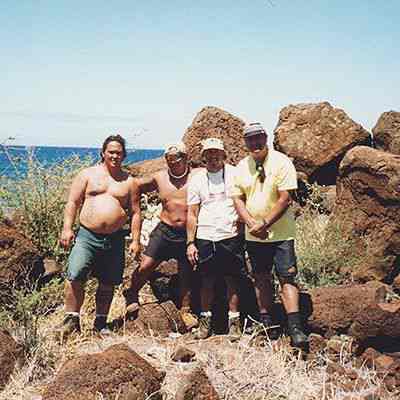 A group of men near pohaku (rocks)